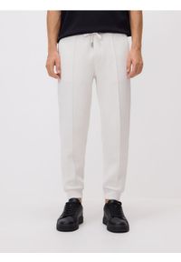 Reserved - Spodnie dresowe slim fit - złamana biel. Materiał: dresówka