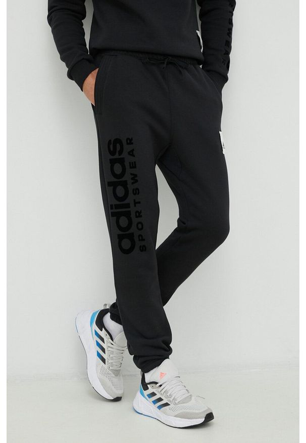 Adidas - adidas spodnie dresowe kolor czarny z aplikacją. Kolor: czarny. Materiał: dresówka. Wzór: aplikacja