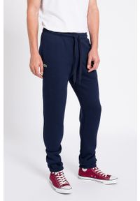 Lacoste spodnie męskie kolor granatowy joggery. Kolor: niebieski. Materiał: dzianina. Wzór: gładki