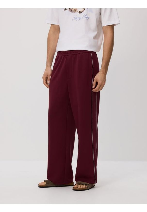 Reserved - Spodnie loose fit - mahoniowy. Kolor: brązowy. Materiał: wiskoza, dzianina