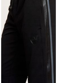 EA7 Emporio Armani - EA7 Spodnie dresowe z lampasami. Kolor: czarny. Materiał: poliester. Wzór: aplikacja
