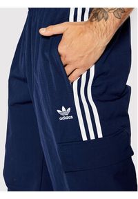 Adidas - adidas Spodnie dresowe adicolor 3-Stripes Cargo HN6735 Granatowy Relaxed Fit. Kolor: niebieski. Materiał: dresówka, syntetyk