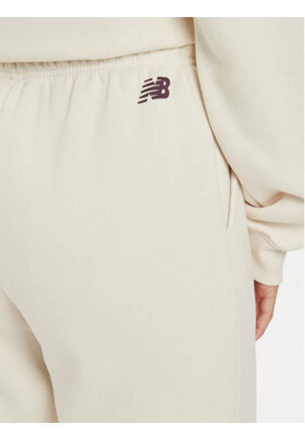 New Balance Spodnie dresowe WP43500 Beżowy Relaxed Fit. Kolor: beżowy. Materiał: syntetyk