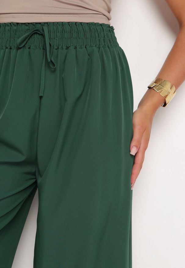 Born2be - Ciemnozielone Szerokie Spodnie z Wysokim Stanem Wiskozą i Gumką w Pasie Criseldas. Okazja: do pracy, na co dzień, na spotkanie biznesowe. Stan: podwyższony. Kolor: zielony. Materiał: wiskoza. Długość: długie. Styl: casual, elegancki, biznesowy