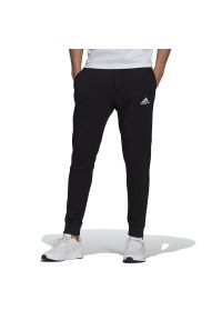 Adidas - Spodnie dresowe adidas Essentials Fleece Regular Fit Tapered Cuff GK9268 - czarne. Kolor: czarny. Materiał: dresówka