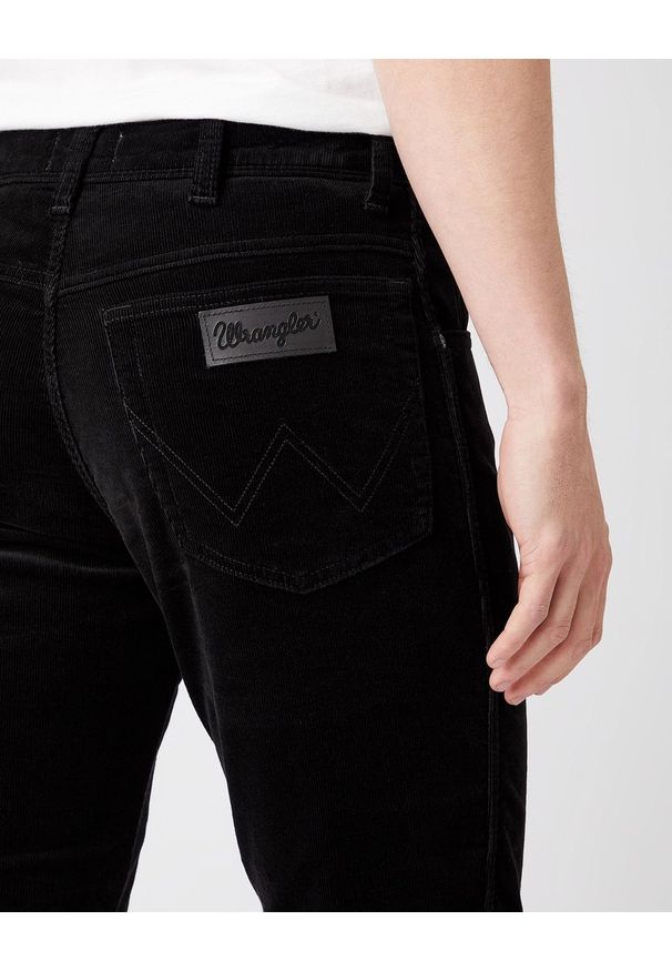 Wrangler - MĘSKIE SPODNIE SZTRUKSOWE WRANGLER TEXAS SLIM BLACK W12SEC100 112141146. Materiał: sztruks. Długość: długie. Wzór: aplikacja, prążki, napisy. Sezon: wiosna, zima, jesień