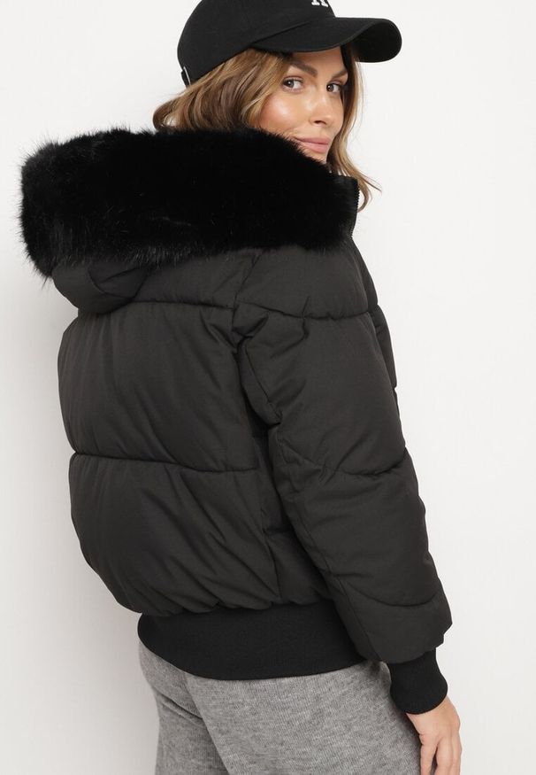 Born2be - Czarna Pikowana Kurtka z Szerokimi Ściągaczami i Ozdobnym Futrem przy Kapturze Inandria. Okazja: na co dzień, na spotkanie biznesowe, do pracy. Kolor: czarny. Materiał: futro. Długość rękawa: długi rękaw. Długość: długie. Styl: biznesowy, casual, elegancki, klasyczny