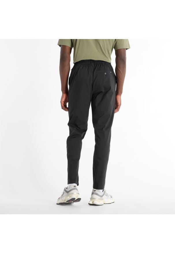 Spodnie męskie New Balance MP43554BK – czarne. Kolor: czarny. Materiał: nylon, bawełna, materiał. Wzór: aplikacja