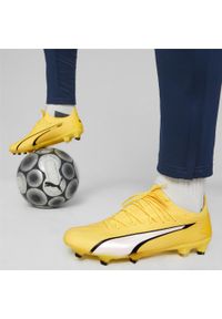 Buty piłkarskie Puma Ultra Ultimate FG/AG. Kolor: biały, czarny, żółty, wielokolorowy. Materiał: syntetyk, materiał. Szerokość cholewki: normalna. Sport: piłka nożna