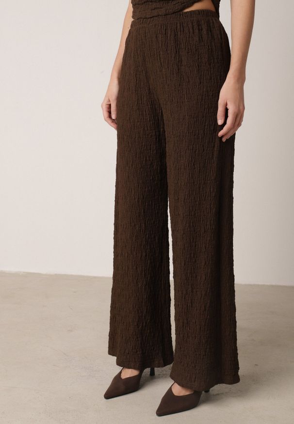 Born2be - Brązowy Gładki Komplet Szerokie Spodnie i Marszczona Bluzka ze Stójką Merithie. Kolor: brązowy. Materiał: materiał. Wzór: gładki