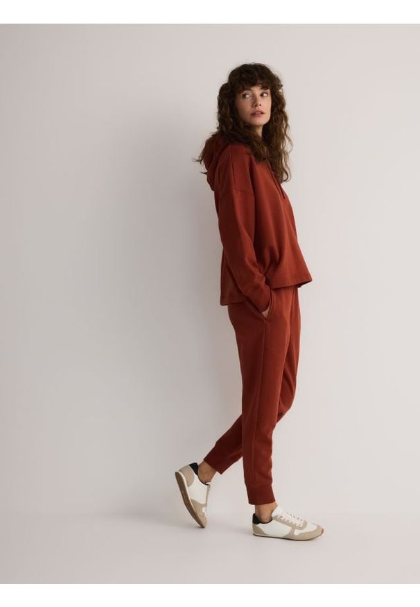 Reserved - Spodnie jogger z wiązaniem w pasie - bordowy. Kolor: czerwony. Materiał: dzianina, bawełna