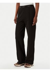 Calvin Klein Jeans Spodnie dresowe LV047G253G Brązowy ciemny Relaxed Fit. Kolor: brązowy. Materiał: bawełna #1
