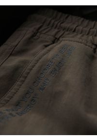 Ombre Clothing - Męskie spodnie joggery z kieszeniami cargo i printem – ciemnooliwkowe V5. Okazja: na co dzień. Kolor: oliwkowy. Materiał: guma, tkanina, poliester, materiał, bawełna, elastan. Wzór: nadruk. Styl: casual #2