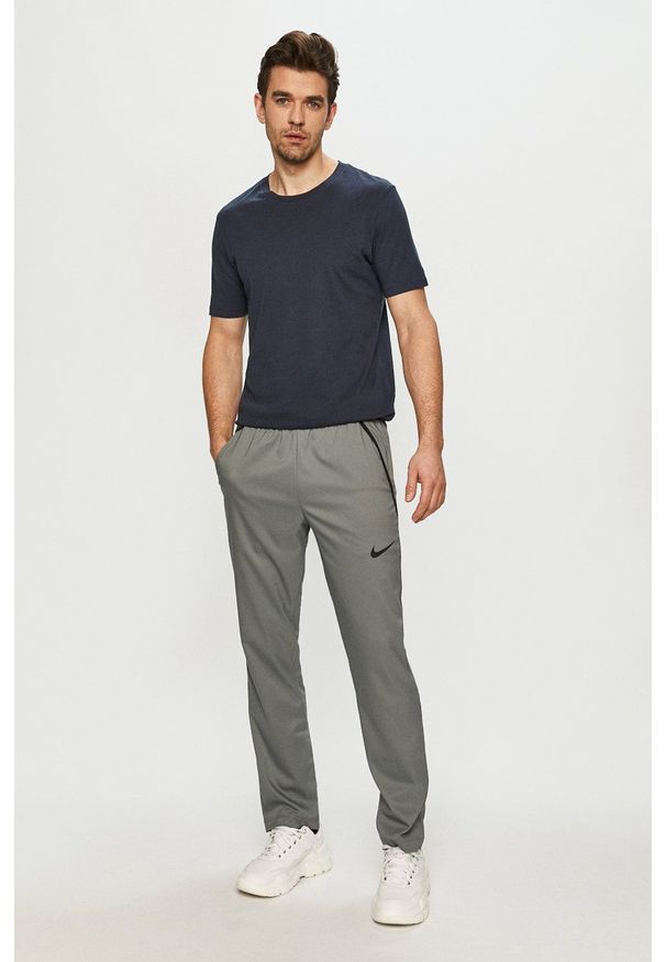 Nike - Spodnie. Okazja: na co dzień. Kolor: szary. Materiał: tkanina, włókno, skóra. Styl: casual