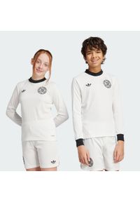 Adidas - Koszulka Germany Anniversary Long Sleeve Kids. Kolor: biały, wielokolorowy, czarny. Materiał: materiał. Długość rękawa: długi rękaw