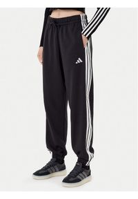Adidas - adidas Spodnie dresowe Essentials 3-Stripes Fleece JE1276 Czarny Loose Fit. Kolor: czarny. Materiał: bawełna #1