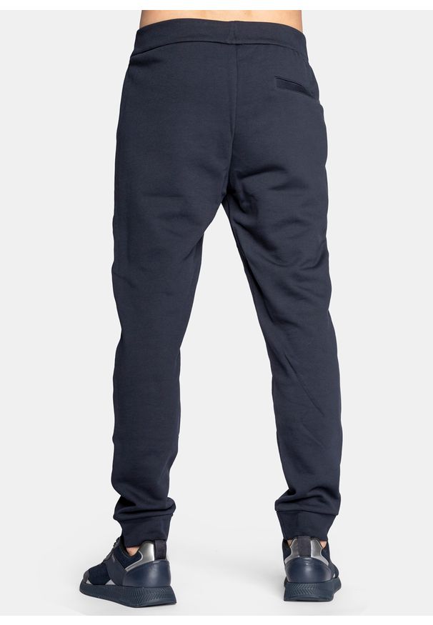 Spodnie dresowe męskie granatowe Armani Exchange 8NZPPA ZJ1ZZ 1510. Kolor: niebieski. Materiał: dresówka. Sport: turystyka piesza