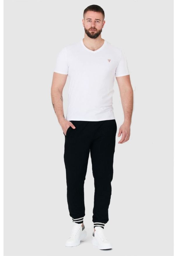 Guess - GUESS Czarne męskie spodnie dresowe. Kolor: czarny. Materiał: bawełna. Wzór: aplikacja