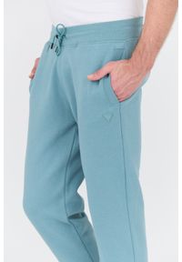 Guess - GUESS Turkusowe spodnie dresowe Aldwin. Kolor: niebieski. Materiał: dresówka #6