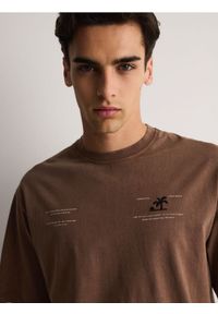 Reserved - T-shirt oversize z nadrukiem na plecach - ciemnobrązowy. Kolor: brązowy. Materiał: bawełna, dzianina. Wzór: nadruk