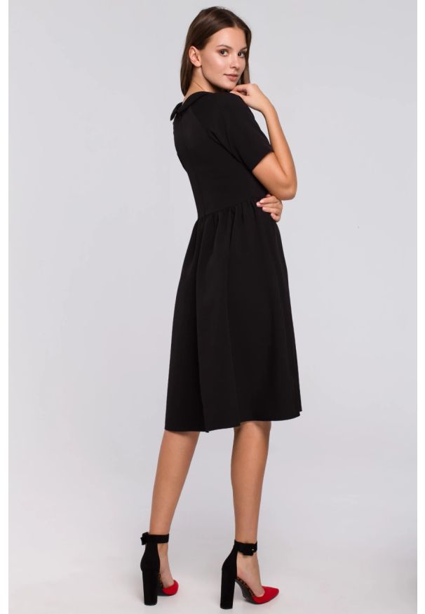 Sukienki.shop - Elegancka rozkloszowana sukienka z wywiniętą stójką czarna. Okazja: do pracy. Typ kołnierza: kołnierzyk stójkowy. Kolor: czarny. Styl: elegancki