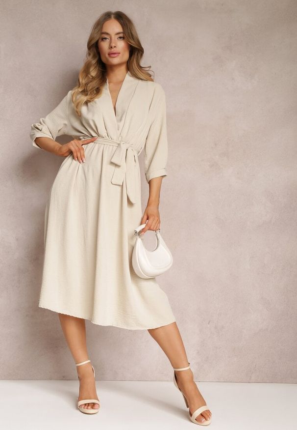 Renee - Beżowa Sukienka Canopis. Typ kołnierza: dekolt kopertowy. Kolor: beżowy. Materiał: tkanina, materiał. Typ sukienki: kopertowe. Styl: elegancki. Długość: midi