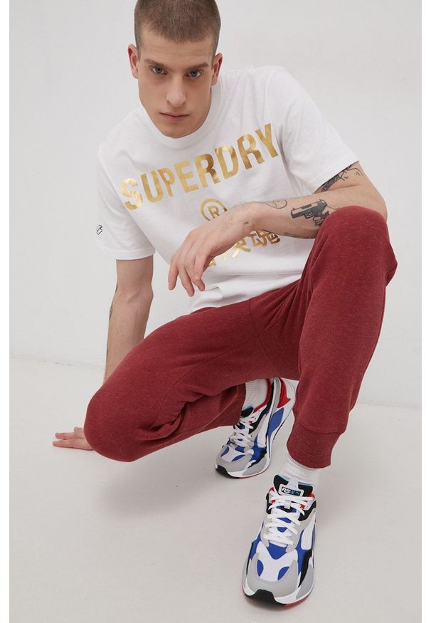 Superdry Spodnie męskie kolor bordowy gładkie. Kolor: czerwony. Materiał: dzianina. Wzór: gładki