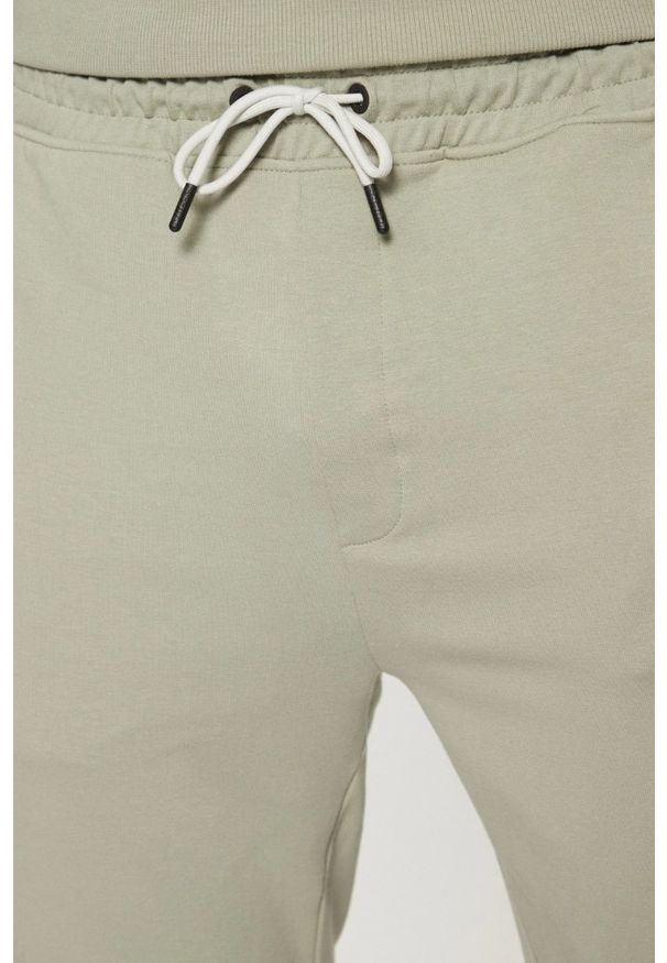 Guess - GUESS Zielone męskie spodnie dresowe z lampasami New Arlo, Rozmiar XL. Kolor: zielony. Materiał: dresówka