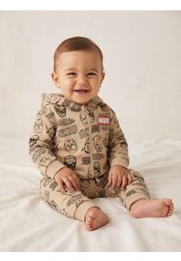 Sinsay - Spodnie dresowe jogger ze wzorem Marvel - beżowy. Kolor: beżowy. Materiał: dresówka. Wzór: motyw z bajki #1