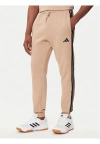 Adidas - adidas Spodnie dresowe Essentials 3-Stripes JX0712 Beżowy Regular Fit. Kolor: beżowy. Materiał: syntetyk, bawełna