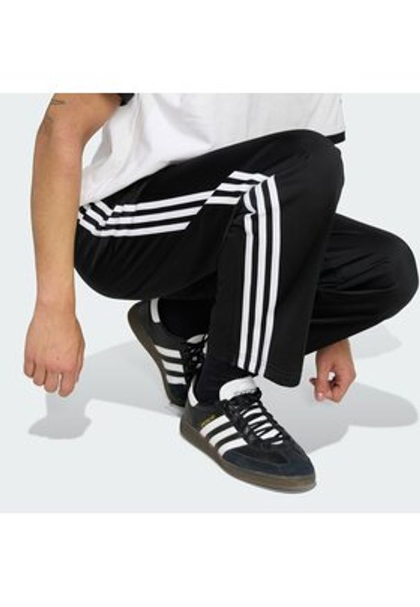 Adidas - adidas Spodnie dresowe Firebird KD8315 Czarny Loose Fit. Kolor: czarny. Materiał: syntetyk