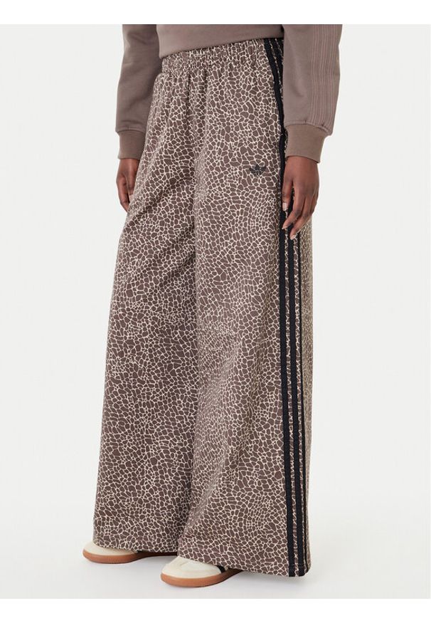 Adidas - adidas Jeansy Firebird Aop KD8811 Brązowy Loose Fit. Kolor: brązowy