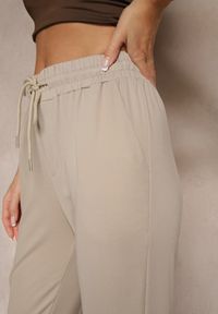 Renee - Beżowe Spodnie Dresowe z Wiskozą High Waist Ozdobione Sznurkiem Ellivenna. Okazja: na co dzień. Stan: podwyższony. Kolor: beżowy. Materiał: dresówka, wiskoza. Wzór: aplikacja. Styl: sportowy, casual
