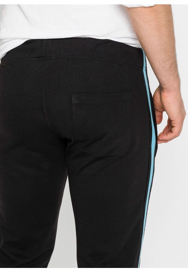 bonprix - Spodnie sportowe z kontrastowymi elementami. Kolor: czarny. Materiał: dresówka. Styl: sportowy
