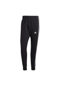 Adidas - Essentials French Terry Tapered Cuff 3-Stripes Pants. Kolor: biały, czarny, niebieski, wielokolorowy. Materiał: dresówka