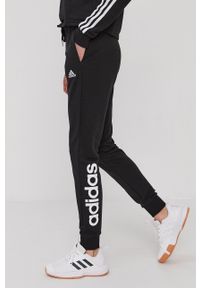 Adidas - adidas Spodnie damskie kolor czarny z nadrukiem. Kolor: czarny. Materiał: poliester. Wzór: nadruk