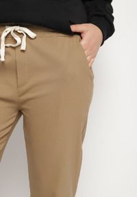 Born2be - Ciemnobeżowe Spodnie z Bawełny z Powiniętymi Nogawkami i Sznurkiem Savarile. Okazja: na co dzień. Kolor: beżowy. Materiał: bawełna. Styl: casual #7
