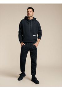 Sinsay - Sportowe spodnie dresowe z przeszyciami - czarny. Kolor: czarny. Materiał: dresówka. Styl: sportowy