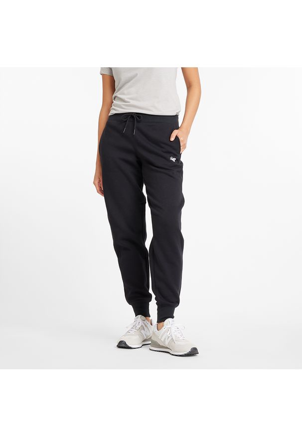 Spodnie damskie New Balance WP43805BK – czarne. Stan: podwyższony. Kolor: czarny. Materiał: poliester, bawełna, dresówka