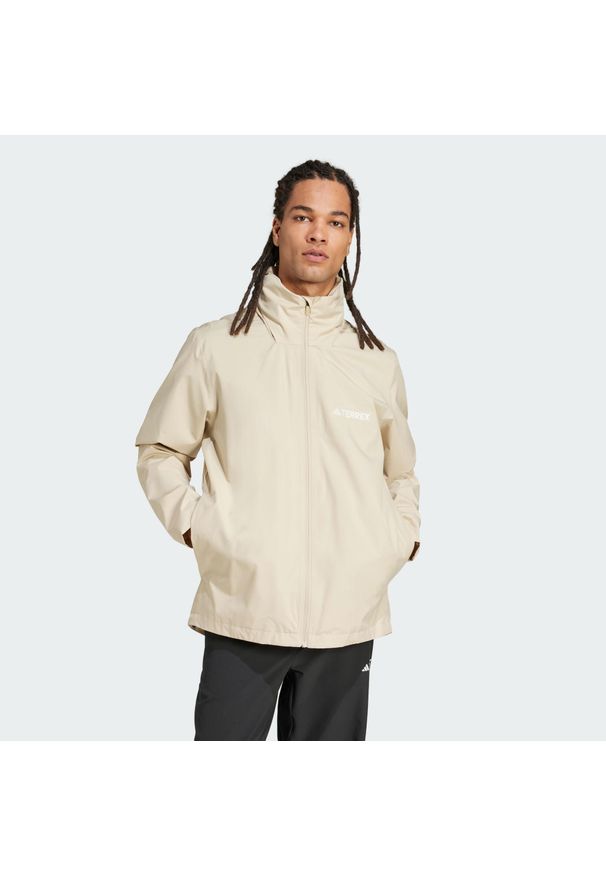 Adidas - Kurtka Multi Essentials 2L Rain. Kolor: beżowy. Technologia: ClimaProof (Adidas)
