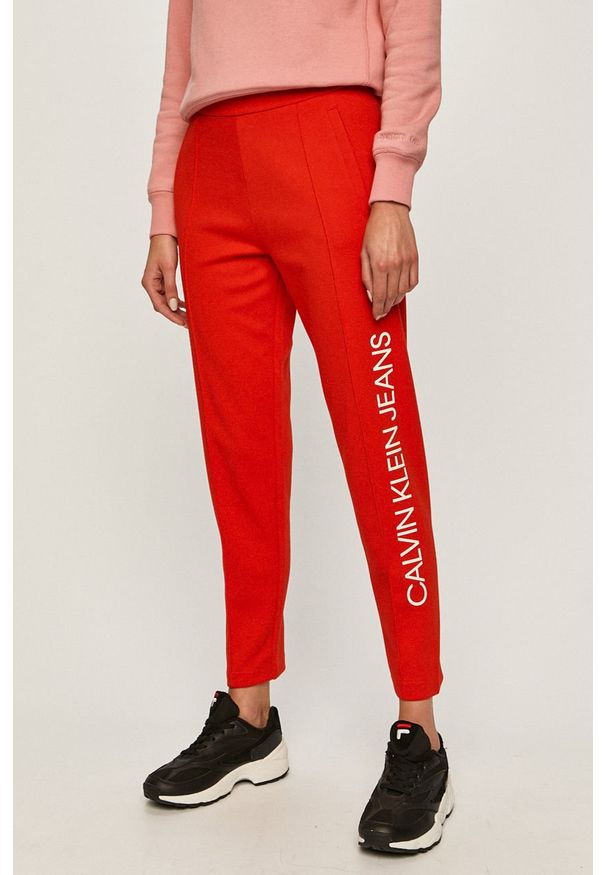 Calvin Klein Jeans - Spodnie. Stan: podwyższony. Kolor: czerwony. Materiał: bawełna, poliester, dzianina. Wzór: nadruk, gładki
