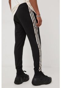 Adidas - adidas spodnie dresowe męskie kolor czarny z aplikacją. Kolor: czarny. Materiał: dresówka. Wzór: aplikacja
