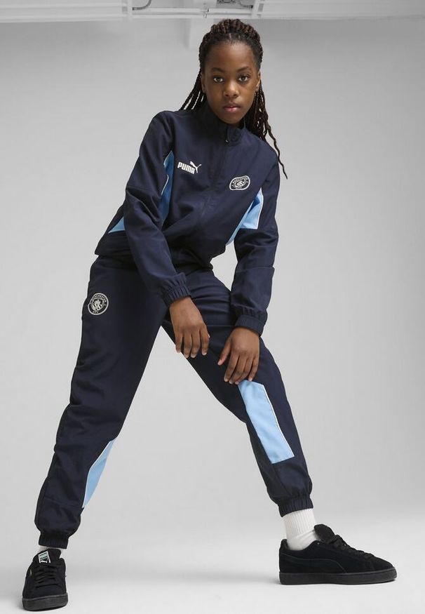 Puma - Młodzieżowe spodnie Manchester City ftblARCHIVE PUMA Navy Team Light Blue. Kolor: niebieski