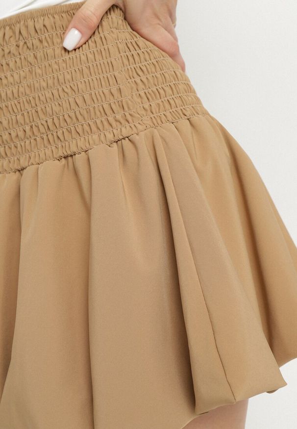 Born2be - Ciemnobeżowa Rozkloszowana Spódnica Bufiasta z Elastyczną Gumką w Pasie Hetilda. Okazja: na co dzień, na spotkanie biznesowe. Stan: podwyższony. Kolor: beżowy. Styl: biznesowy, casual, elegancki