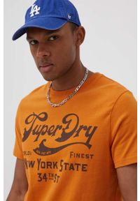 Superdry T-shirt bawełniany kolor pomarańczowy z nadrukiem. Okazja: na co dzień. Kolor: pomarańczowy. Materiał: bawełna. Wzór: nadruk. Styl: casual