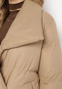 Born2be - Ciemnobeżowa Kurtka Płaszcz Zapinana na Napy Ukryte pod Plisą z Kieszeniami i Paskiem Ritallas. Typ kołnierza: kołnierzyk stójkowy. Kolor: beżowy. Materiał: materiał. Długość: długie. Sezon: zima #2