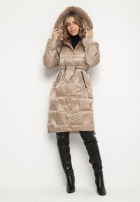 Born2be - Ciemnobeżowa Pikowana Kurtka o Długim Kroju ze Ściągaczem w Talii i Kapturem Galita. Okazja: na co dzień. Kolor: beżowy. Materiał: dzianina, poliester, jeans, futro. Długość: długie. Styl: casual, elegancki #1