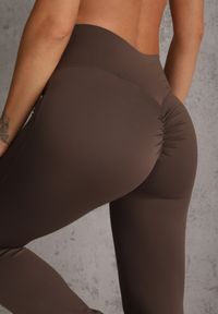 Renee - Brązowe Legginsy Flare High Waist Ozdobione z Tyłu Modelującym Marszczeniem Deinoreia. Okazja: na co dzień. Stan: podwyższony. Kolor: brązowy. Wzór: aplikacja. Styl: elegancki, casual #5