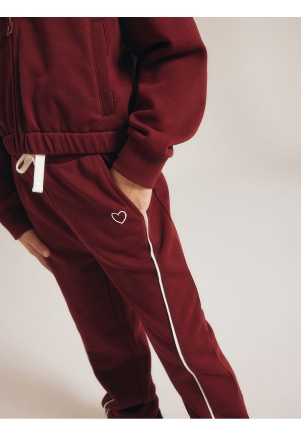 Reserved - Spodnie dresowe z przeszyciami - bordowy. Kolor: czerwony. Materiał: dresówka