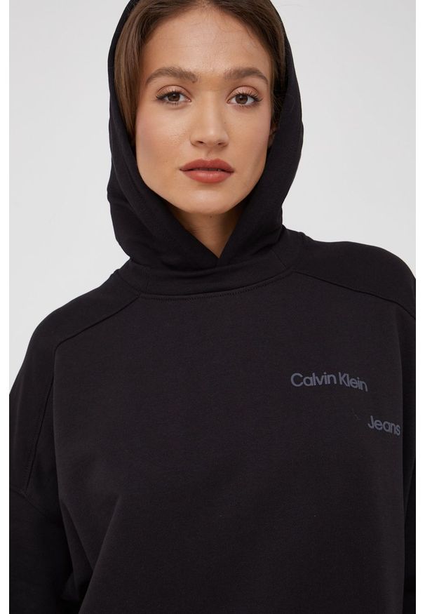 Calvin Klein Jeans bluza kolor czarny z kapturem gładka. Typ kołnierza: kaptur. Kolor: czarny. Materiał: bawełna, dzianina, włókno, lyocell. Wzór: gładki